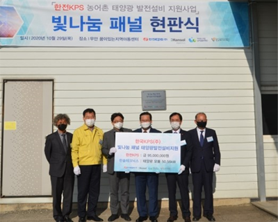 Attendees holding a solar power facility support sign at the KEPCO KPS Light Sharing Panel ceremony